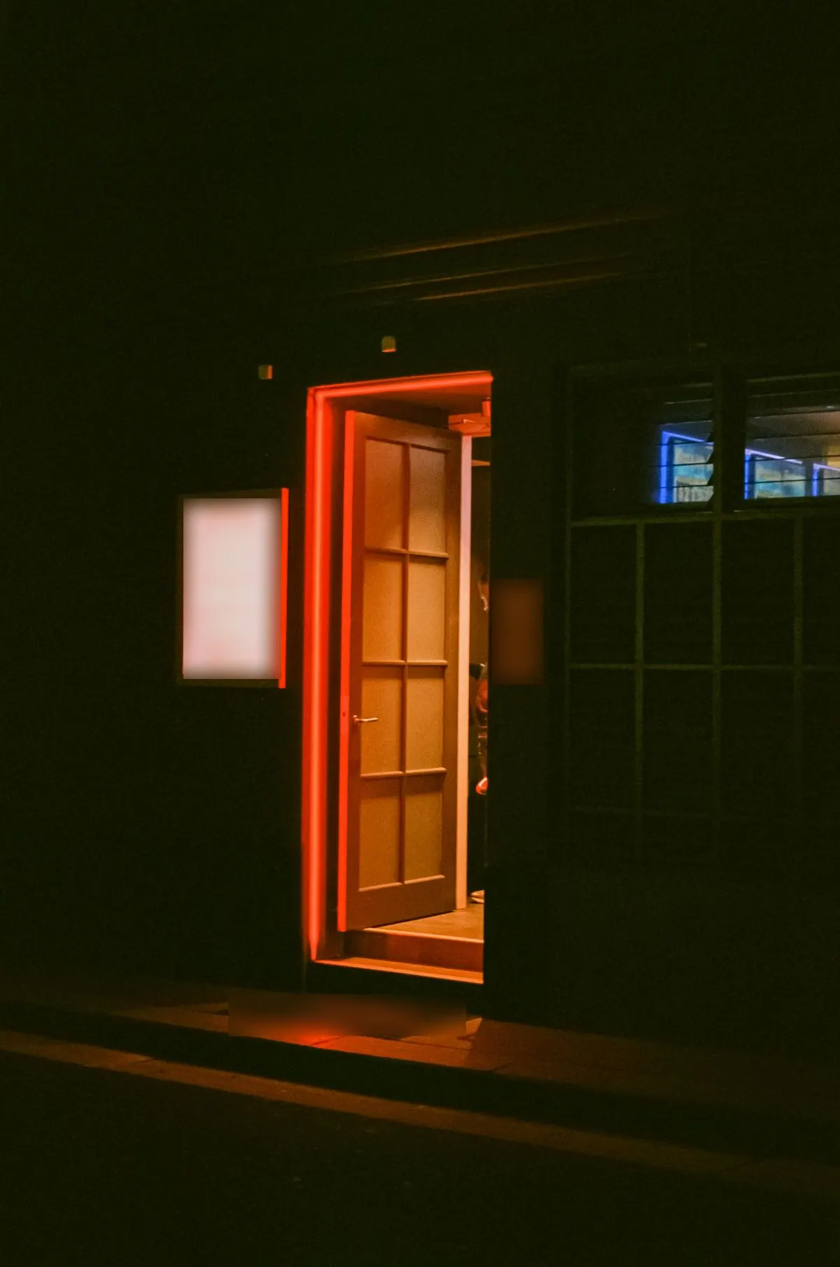 A door left open at night with warm light inside